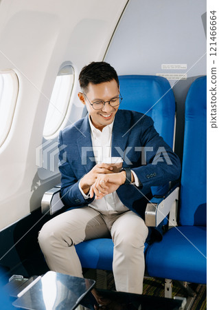Asian executive excels in first class, multitasking with digital tablet, laptop and smartphone. Travel in style Asian executive excels in first class, multitasking with digital tablet, laptop and smartphone. Travel in style 121466664