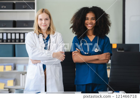 Successful team female doctor standing at table, looking at camera. Successful team female doctor standing at table, looking at camera. 121466718