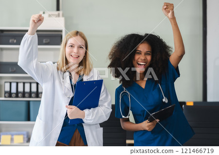 Successful team female doctor standing at table, looking at camera. Successful team female doctor standing at table, looking at camera. 121466719