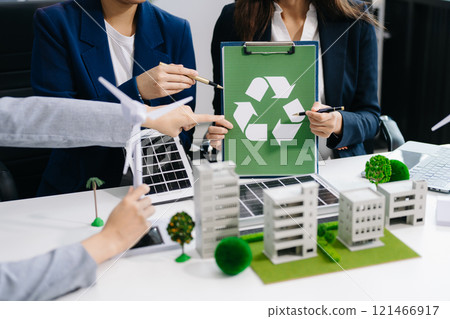 Business people having consultation about wind energy at company office. Business team discussing about windmill and alternative green enery. Executive meeting 121466917