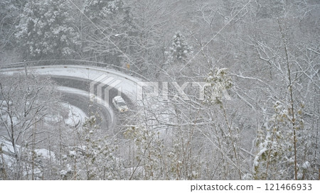 Car driving on a snowy mountain pass 121466933