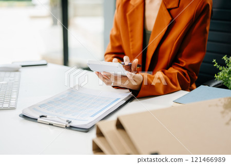Women counting coins on calculator taking from the piggy bank. hand holding pen working on calculator 121466989