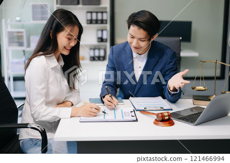 Two lawyers are discussing about contract paper, law matters determination, pointing.law and hammer on the table Two lawyers are discussing about contract paper, law matters determination, pointing.law and hammer on the table 121466994