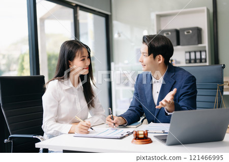 Two lawyers are discussing about contract paper, law matters determination, pointing.law and hammer on the table Two lawyers are discussing about contract paper, law matters determination, pointing.law and hammer on the table 121466995