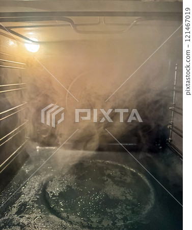 Steam Rising Inside a Hot Oven During Cleaning Process. High quality photo Steam Rising Inside a Hot Oven During Cleaning Process. High quality photo 121467019