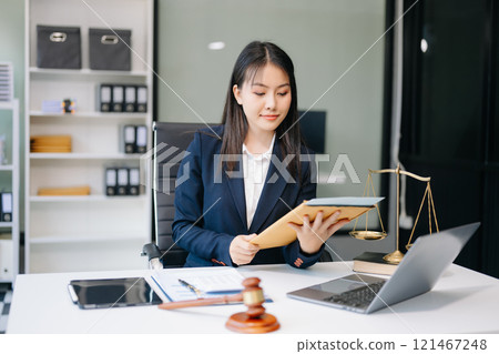 Asian woman lawyer working and gavel, tablet, laptop in front, Advice justice and law concept. 121467248