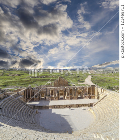 Amphitheater in Jerash (Gerasa of Antiquity), capital and largest city of Jerash Governorate, Jordan. Against the background of a beautiful sky with clouds 121468711