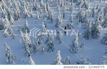 Aerial view of ski touring man and woman with snow shoes crossing winter mountains, fresh snow. 121468773