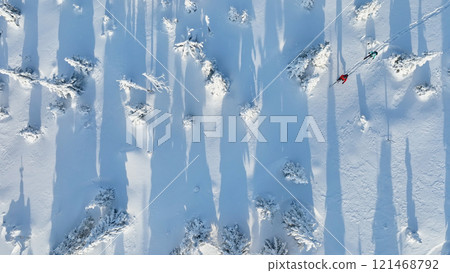 Aerial view of ski touring man and woman with snow shoes crossing winter mountains, fresh snow. Aerial view of ski touring man and woman with snow shoes crossing winter mountains, fresh snow. 121468792