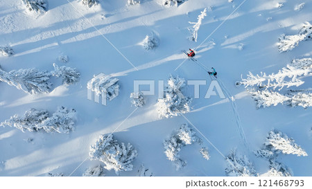 Aerial view of ski touring man and woman with snow shoes crossing winter mountains, fresh snow. 121468793