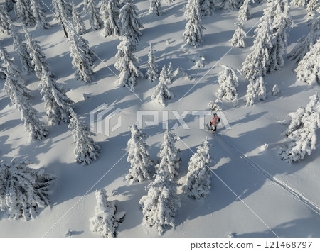 Aerial view of ski touring man crossing winter mountains, fresh snow. 121468797