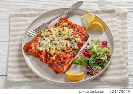 baked salmon topped with blue cheese on a plate baked salmon topped with blue cheese on a plate 121470049