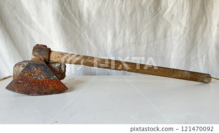 Rusty tool on a white surface showcasing its weathered condition 121470092