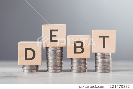 Stack of coins neatly arranged on top of a wooden block labeled "DEBT," symbolizing financial burdens and the weight of monetary obligations, set against a neutral background to emphasize the concept Stack of coins neatly arranged on top of a wooden block labeled "DEBT," symbolizing financial burdens and the weight of monetary obligations, set against a neutral background to emphasize the concept 121470882