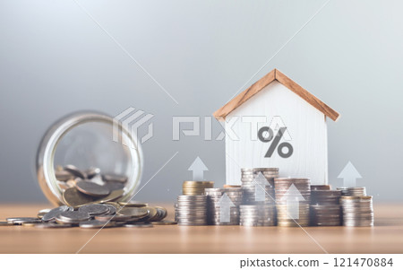 Stacks of coins arranged in ascending order with a small house model placed on a table, Home loan interest, mortgage refinancing, saving for housing, Planning for homeownership and stability Stacks of coins arranged in ascending order with a small house model placed on a table, Home loan interest, mortgage refinancing, saving for housing, Planning for homeownership and stability 121470884