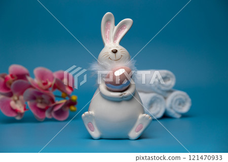 Easter white bunny with brown egg blue background and white towels. Easter 121470933