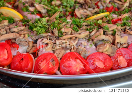 Big pan of andouillettte dish with the vegetables on a market Big pan of andouillettte dish with the vegetables on a market 121471380