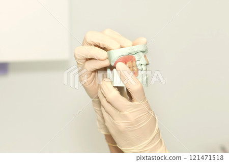 Dentist shows impression of teeth wearing gloves Dentist shows impression of teeth wearing gloves 121471518
