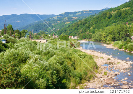 tysa river running through the valley. forest on the hill. sunny weather in summer. mountainous countryside landscape of rakhiv region in ukraine. carpathian mountains tysa river running through the valley. forest on the hill. sunny weather in summer. mountainous countryside landscape of rakhiv region in ukraine. carpathian mountains 121471762
