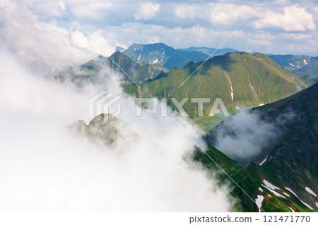 clouds in the mountains. dynamic cloudscape. landscape of transylvania alps on a sunny summer day. scenery with steep rocky slopes with grass and snow. beautiful nature background. picturesque romania clouds in the mountains. dynamic cloudscape. landscape of transylvania alps on a sunny summer day. scenery with steep rocky slopes with grass and snow. beautiful nature background. picturesque romania 121471770
