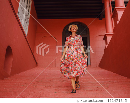 woman in dress and hat exploring vibrant streets of Malacca, Malaysia. 121471845