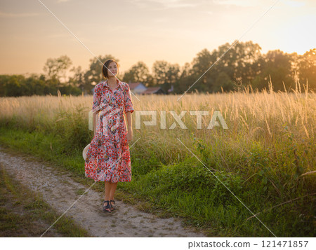 boho chic woman in a floral dress in European countryside 121471857