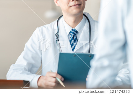 Middle-aged male doctor conducting a medical interview, no face 121474253