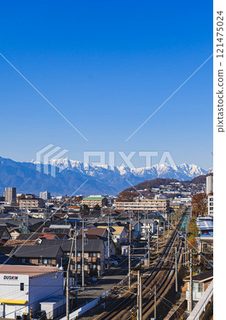 白雪皚皚的北阿爾卑斯山和松本市的鐵軌 121475024