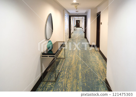 A corridor on the floor of a residential building with light walls and flooring 121475303