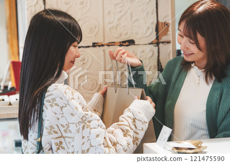 A female customer receives a purchased item from a store clerk. (Photo courtesy of Nuttari Terrace Shopping Street) 121475590