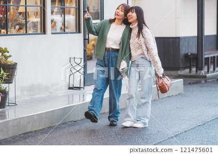 Two women walking through a retro-style shopping street [Photo courtesy of Nuttari Terrace Shopping Street] 121475601