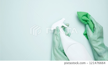 House cleaning. Womans hand in rubber glove holds cloths and cleaning product House cleaning. Womans hand in rubber glove holds cloths and cleaning product 121476664