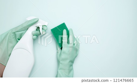 House cleaning. Womans hand in rubber glove holds green dishwashing sponge and cleaning product House cleaning. Womans hand in rubber glove holds green dishwashing sponge and cleaning product 121476665