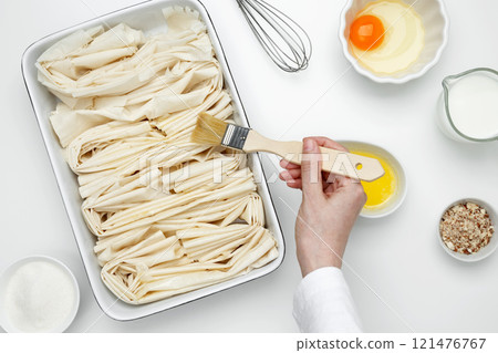 Filo dough in a baking dish near Crinkle Cake butter for buttering 121476767