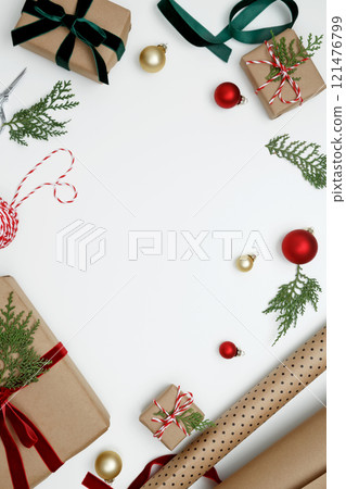 Cozy holiday atmosphere, Christmas gifts being wrapped with festive decorations, ribbons, paper Cozy holiday atmosphere, Christmas gifts being wrapped with festive decorations, ribbons, paper 121476799
