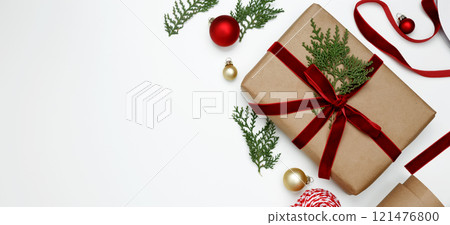 Cozy holiday atmosphere, Christmas gifts being wrapped with festive decorations, ribbons, paper 121476800