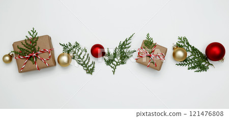 Natural holiday scene. Wrapped Christmas gifts with green thuja branches creating a festive Natural holiday scene. Wrapped Christmas gifts with green thuja branches creating a festive 121476808