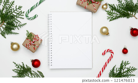 Wrapped Christmas gifts and thuja branches in a festive setup, mockup of white notebook Wrapped Christmas gifts and thuja branches in a festive setup, mockup of white notebook 121476813