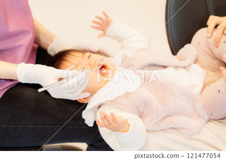 A crying baby undergoing an infant checkup 121477054