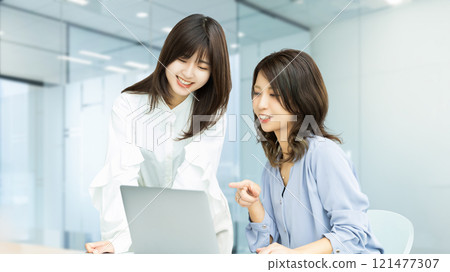 Two women/businesswomen having a meeting using a computer Two women/businesswomen having a meeting using a computer 121477307