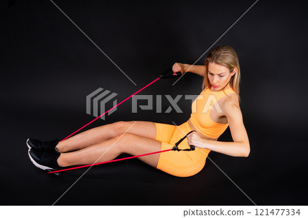 Athletic female performs exercises using a resistance band. Strength and motivation 121477334