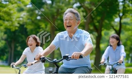 Seniors enjoying a bike ride in nature, laughing 121477581