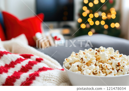 Comfortable sofa with blankets and snacks for Christmas movie time 121478034