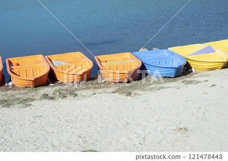 Colorful plastic boats on the shore of a lake, close-up 121478448