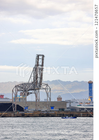 LargeLarge crane works on large coal stockpile at Osaka port. crane works on large coal stockpile at Osaka port. 121478657