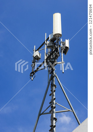 Wireless Communication Antenna pole, Mobile phone mast antenna pole on top of dilapidated building 121478694