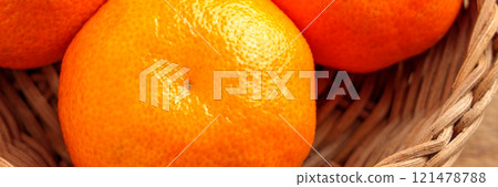 Bright orange tangerines with bumpy textured peel arranged in natural woven basket. Ripe organic citrus fruits. Close up. Top view 121478788