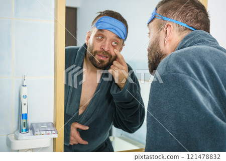 Sleepy man looking at mirror Sleepy man looking at mirror 121478832