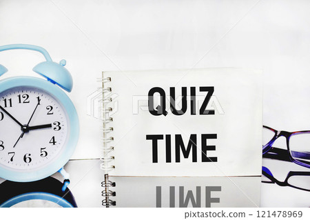 the inscription Quiz Time next to the alarm clock on a white background.  121478969