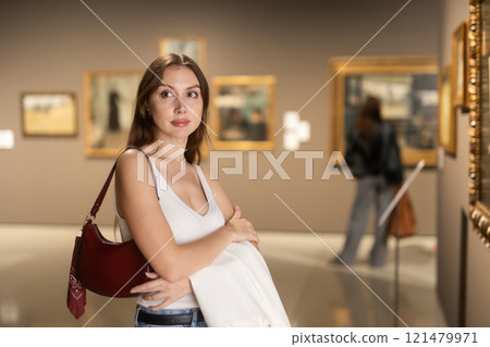 Girl view pictures and icons in museum hall 121479971